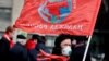 A supporter of the Russian Communist Party goes to lay flowers at the mausoleum of Vladimir Lenin in Moscow. 
