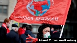 A supporter of the Russian Communist Party goes to lay flowers at the mausoleum of Vladimir Lenin in Moscow. 