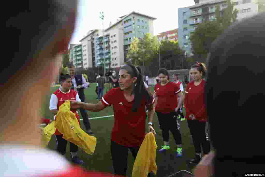 Captain Farkhunda Muhtaj (center) hands out training vests to her teammates during a training session at a soccer pitch in Odivelas on September 30.