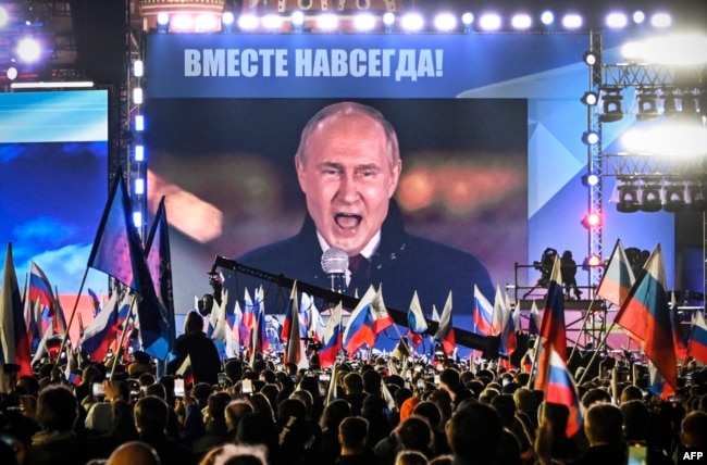 Президент Росії Володимир Путін на екрані, встановленому на Красній площі, виступає на мітингу та концерті, присвячених «анексії чотирьох регіонів України», вересень 2022 року