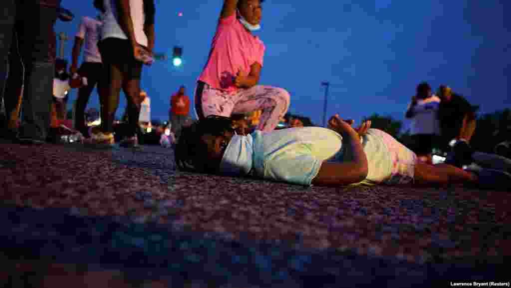 Девушка лежит на животе, как обычно вынуждены лежать те, кого задерживает полиция. Флориссент, штат Миссури