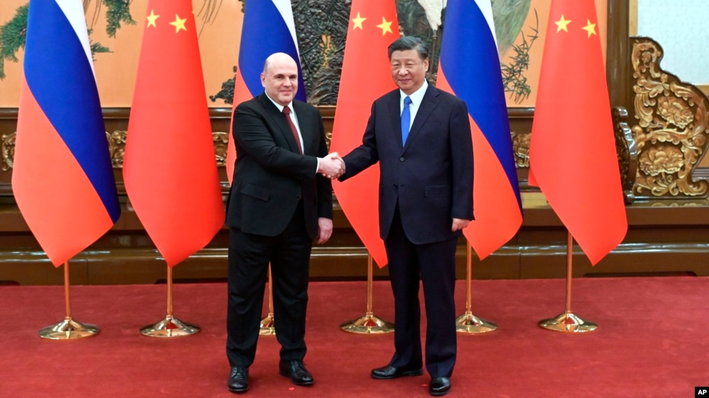 Russian Prime Minister Mikhail Mishustin (left) poses with Chinese President Xi Jinping prior to talks in Beijing on May 24.