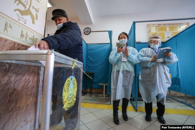 Мужчина бросает бюллетень в урну на одном из избирательных участков в Алматы. 10 января 2021 года.