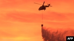 Një helikopter i ushtrisë shqiptare gjatë operacionit për shuarjen e vatrave të zjarrit në Levan, afër Fierit më 4 shtator. 