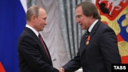 Sergei Roldugin (right) a childhood friend of Vladimir Putin (left), has been implicated in a new report on the wealth of the Russian president's family and friends. (file photo)