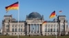 Немецкие флаги развеваются перед зданием Рейхстага, где заседает Бундестаг, архивное фото 