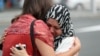 Residents hug after paying respects at a mosque in Auckland, New Zealand, following the attacks in Christchurch.
