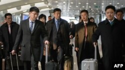 A man understood to be North Korean nuclear envoy Kim Hyok Chol (center, blue tie) at Beijing international airport on February 19