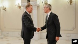 Генералниот секретар на НАТО Јенс Столтенберг, десно, се ракува со романскиот претседател Клаус Јоханис во Букурешт, Романија,
