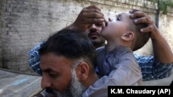 A health worker gives a polio vaccine to a child in Lahore on September 24.