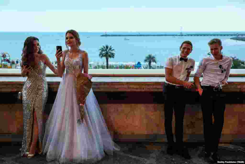 Young people relax after a traditional parade of school leavers through the Russian city of Sochi on June 25. (TASS/Dmitry Feoktistov)&nbsp;