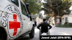 FILE: An Afghan handicapped man passes by a logo of ICRC in the pediatric center of the International Committee of the Red Cross (ICRC) in Kabul on October 10.