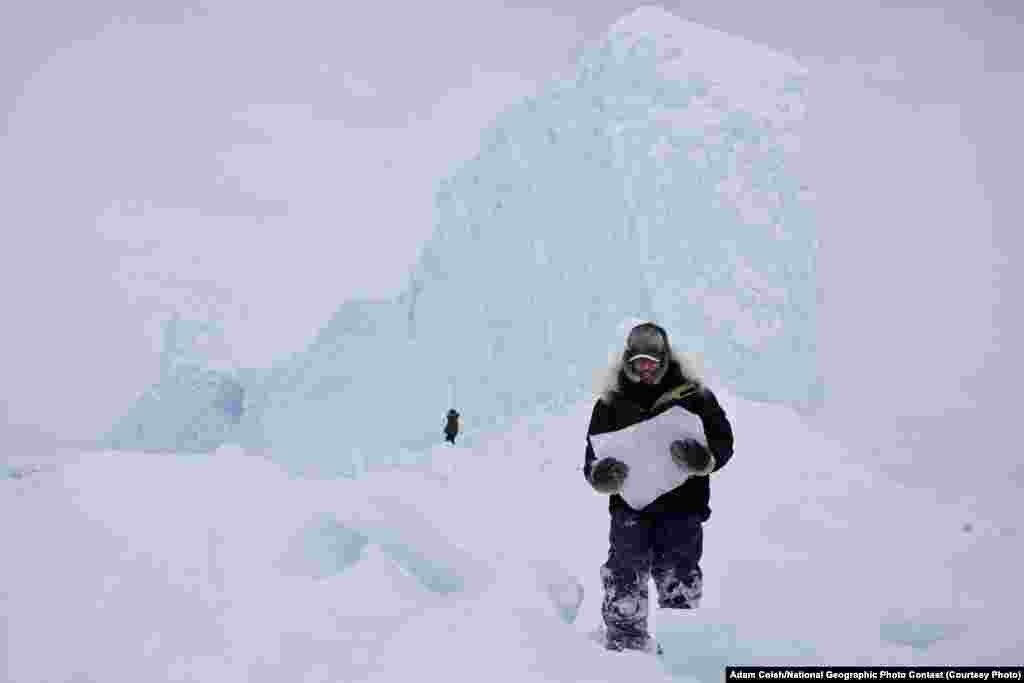 VIEWER&#39;S CHOICE FOR PLACES: Iceberg Hunters (Pond Inlet, Nunavut, Canada) -- Chipping ice off an iceberg is a common way for the Inuit community to retrieve fresh drinking water while on the land. During a weekend-long hunting trip we came upon this majestic iceberg frozen in place. It was a perfect opportunity to grab enough ice and drinking water for the remainder of the trip. (Caption by photographer Adam Coish)