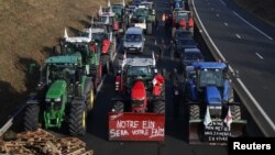 Tractoarele stau la coadă pe autostrada A16 către Paris. Fermierii francezi încearcă să ajungă la Paris în timpul unui protest împotriva presiunilor asupra prețurilor, taxelor și reglementărilor ecologice. 29 ianuarie 2024.
