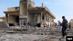 Afghan security officials inspect the site of a suicide bomb blast near the provincial council in Lashkar Gah on March 18.