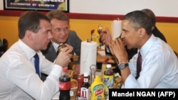 Medvedev watches as Obama digs in at Ray's Hell Burger.