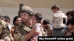 Aeroportul din Kabul | Au existat relatări despre femei care își aruncau copiii peste gardul de sârmă ca să fie luați de americani