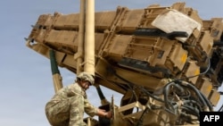 A US Army air defense artilleryman conducts maintenance on an MIM-104 Patriot missile system at an undisclosed location in the Middle East.