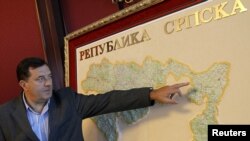 Bosnian Serb then-Prime Minister, and current president, Milorad Dodik shows his place of residence on a map of the Republic of Srpska during an interview with Reuters in Banja Luka, September 1, 2010