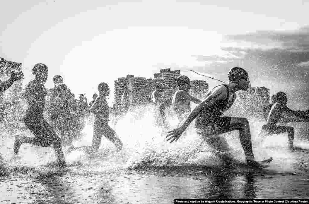 1st Place: &quot;Dig Me River&quot; by Wagner Araujo, taken at Rio Negro, Ponta Negra Beach, Manaus, Brazil: &quot;I was in Manaus, Amazonas, during the Brazilian Aquathlon (swimming and running) championship. I photographed it from the water and my lens got completely wet, but there was so much energy in these boys that I just didn&#39;t worry about that.&quot;