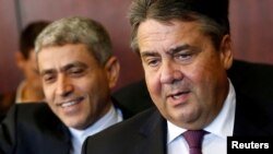 German Economy Minister Sigmar Gabriel (right) and Iran's Economy Minister Ali Tayebnia arrive for a conference in Tehran on October 3. Gabriel flew to Iran with a planeful of 120 managers who are keen to reestablish business relations with the Islamic republic.