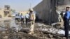 A soldier and policemen inspect the site of a bomb attack at a police station in Baghdad's Hurriyah district.