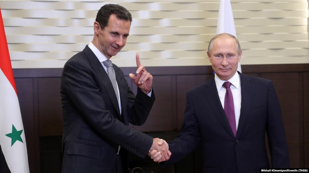 Russian President Vladimir Putin (right) shakes hands with Syrian President Bashar al-Assad during a meeting in the Black Sea resort of Sochi on November 20.