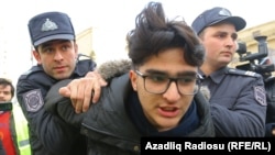 Police detain an activist in Baku ahead of the protest.