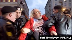 Police and troops detain a participant in the opposition action in Moscow on October 12.