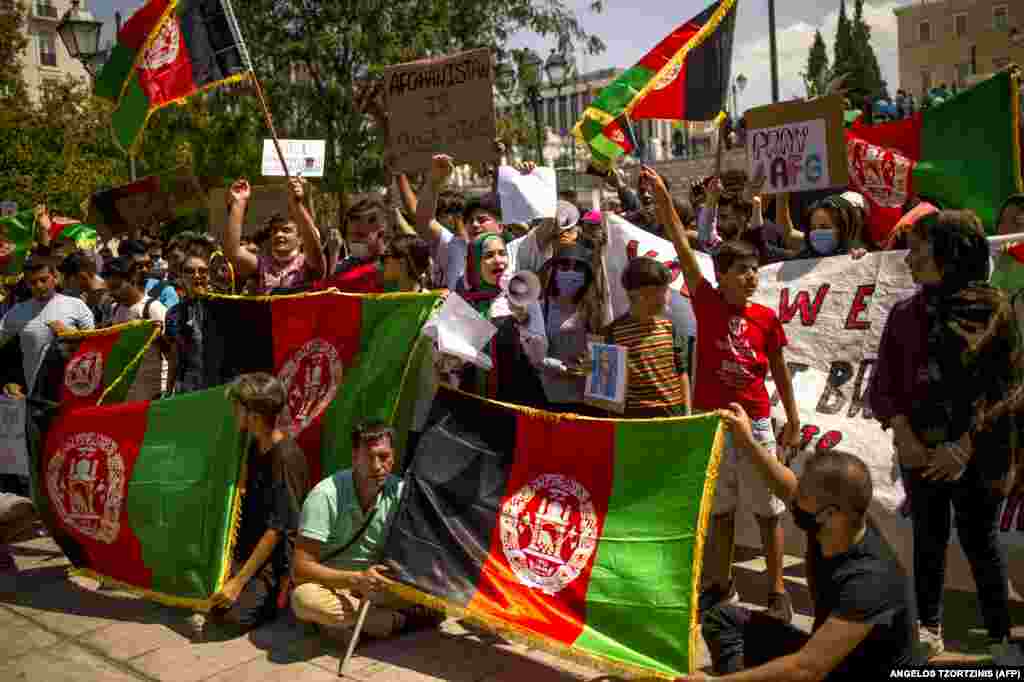 Afganët që jetojnë në Greqi duke mbajtur flamuj afgan teksa merrnin pjesë në një protestë në Athinë, kundër kthimit të talibanëve në pushtet në Afganistan. (18 gusht)