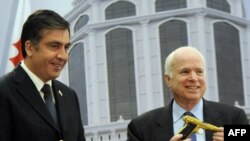 Saakashvili (left) presents the gold-plated pistol to McCain in Batumi.