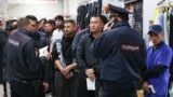 Migrant workers wait for a document check during a raid at a shopping center in Novosibirsk, Russia, on October 15.