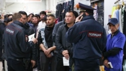 Migrant workers wait for a document check during a raid at a shopping center in Novosibirsk, Russia, on October 15.