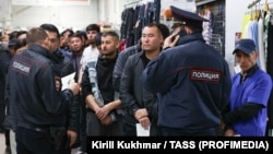 Migrant workers wait for a document check during a raid at a shopping center in Novosibirsk, Russia, on October 15.