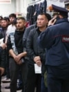 Migrant workers wait for a document check during a raid at a shopping center in Novosibirsk, Russia, on October 15.