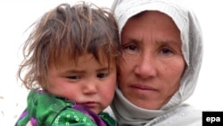 A woman and her child await their turn to get drinking water from a community tap in Baghlan, in northern Afghanistan, earlier this month. Years of conflict and drought have left large sections of the populations without access to clean water.