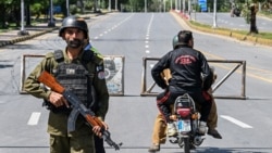 A police officer stands guard at a closed road leading to the Serena Hotel in the Red Zone area of Islamabad on April 19.
