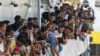 Migrants wait to disembark from the Irish Navy ship LE Niamh in the Sicilian harbor of Messina in July.