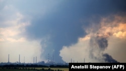 Дым клубится над нефтеперерабатывающим заводом под Лисичанском 23 июня 2022 года на фоне военного вторжения России в Украину