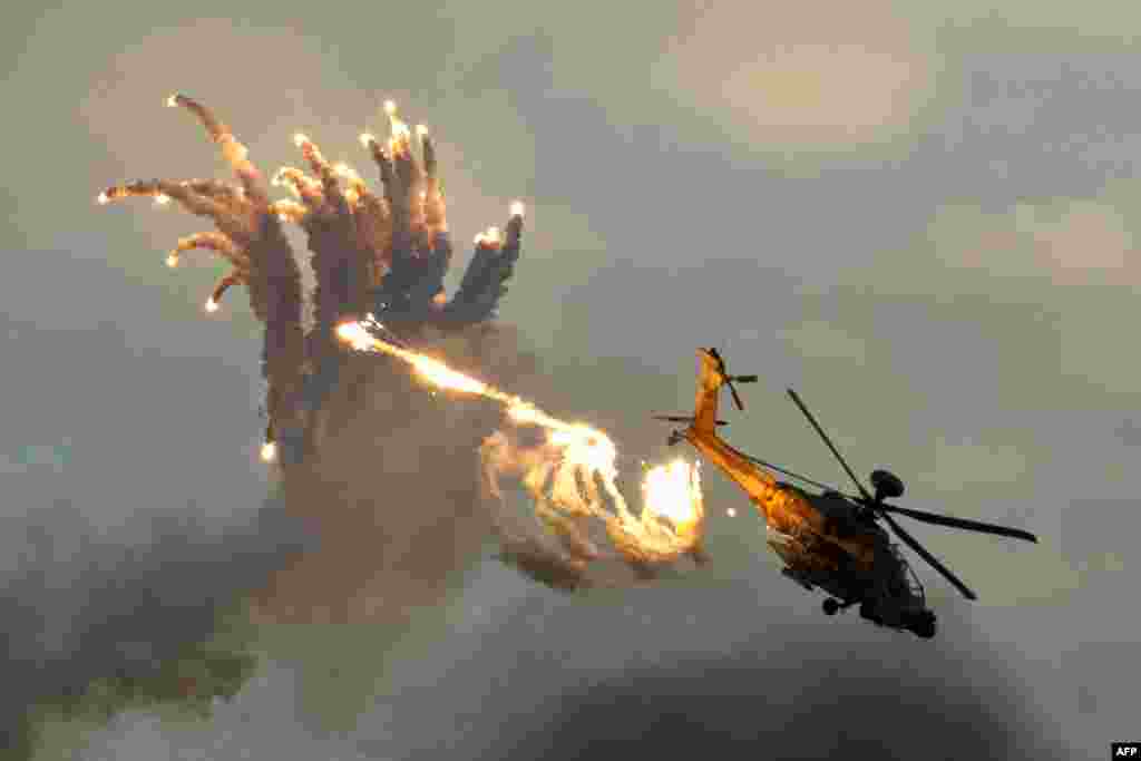 A Boeing AH-64 Apache helicopter launches antimissile flares during an air show at the graduation ceremony of pilots at the Hatzerim Air Force base in the Negev desert, near the southern Israeli city of Beersheva. (AFP/ Jack Guez)