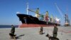 Security guards with their sniffer dogs patrol in front of a cargo ship in the port of Chabahar on the Gulf of Oman, southeastern Iran, near the Pakistani border, Sunday, Dec. 3, 2017. FILE