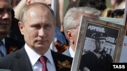 Vladimir Putin atasının portreti ilə "Ölməz batalyon" yürüşündə (2016-cı il)
