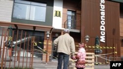 Чоловік з дитиною дивляться на закрите приміщення McDonald's у Сімферополі, 4 квітня 2014 року