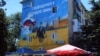 <p>Pedestrians walk by a mural depicting Russian President Vladimir Putin dressed as a Russian Navy seaman, in the Crimean city of Sevastopol. (AFP Yury Lashov)</p>
