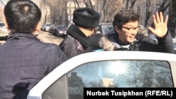 На скриншоте из видео — полицейский усаживает гражданского активиста Галыма Агелеуова в машину. Алматы, 23 февраля 2017 года.