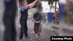 Кадр с видео, на котором запечатлено, как подозреваемый истязает свою жену.
