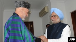 Indian Prime Minister Manmohan Singh (right) shakes hands with Afghan President Hamid Karzai in New Delhi on December 13. 