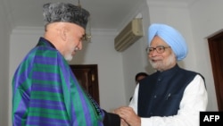 Indian Prime Minister Manmohan Singh (right) shakes hands with Afghan President Hamid Karzai in New Delhi on December 13.