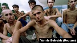 In this photo by Yannis Behrakis, emaciated Muslim refugees, released from a Croat prison, wait for lunch in Jablanica, central Bosnia, in September 1993. 