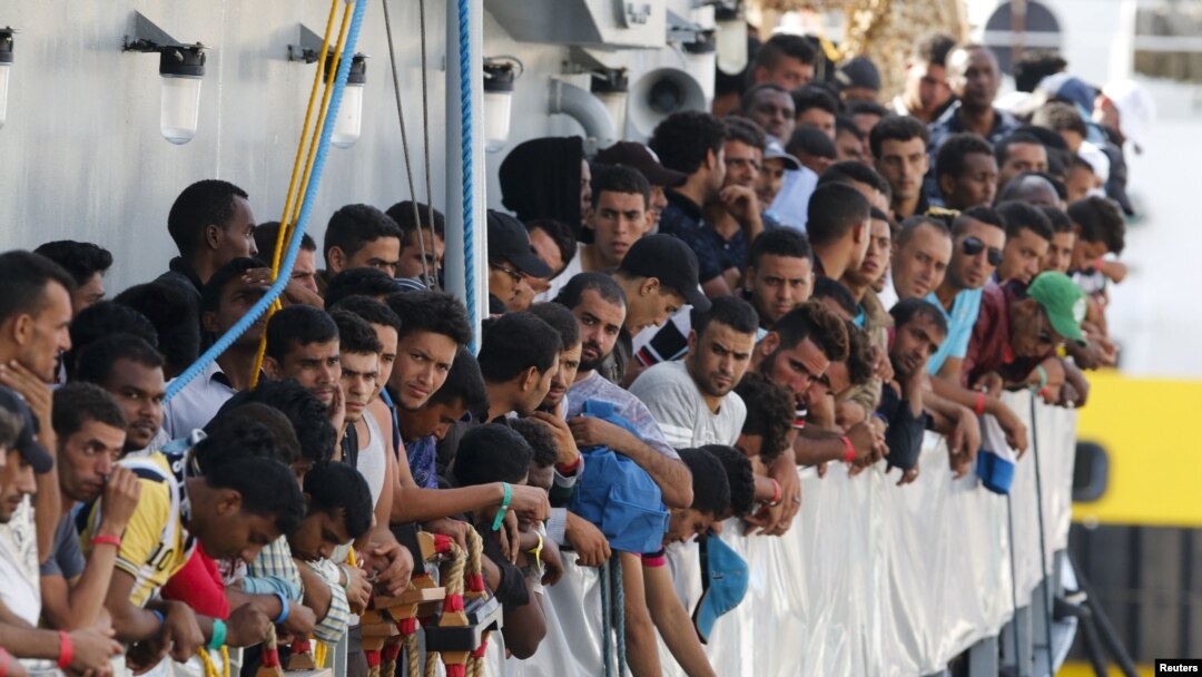 Migrants wait to disembark from the Irish Navy ship LE Niamh in the Sicilian harbor of Messina in July.